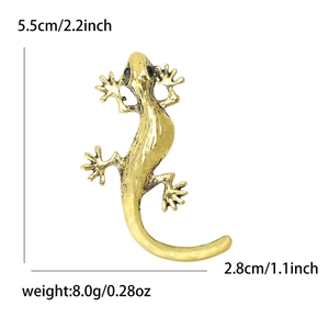 Golden gecko lizard brooch with black gemstone eyes and textured surface details