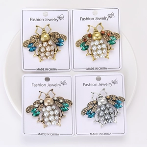 Detail view of retro bee brooches with crystal wings and pearl bodies in mixed colors