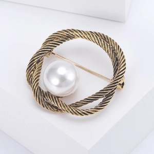 Broche circulaire dorée vintage tressée avec perle blanche sur support géométrique