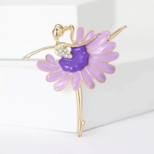Detailed close-up of a golden ballerina brooch with purple enamel and sparkling rhinestones