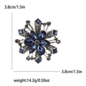 Elegant snowflake brooch with blue pear-shaped rhinestones and silver metal finish