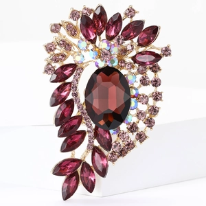 Detailed macro view of vintage alloy brooch with faceted dark red gemstone and crystals