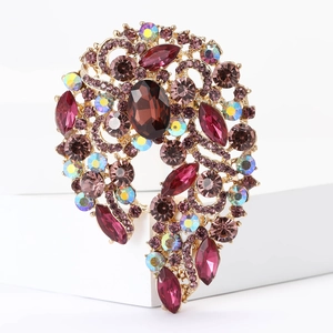 Macro detail of large purple crystal brooch with magenta rhinestones on gold alloy base