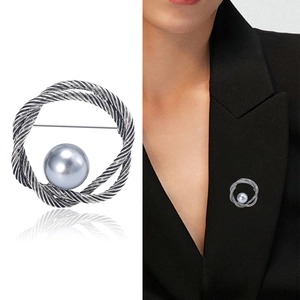 Broche ronde vintage en métal argenté torsadé avec perle grise sur revers noir