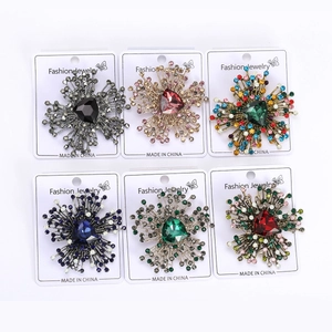 Macro detail of six vintage starburst brooches with triangular crystals on jewelry cards