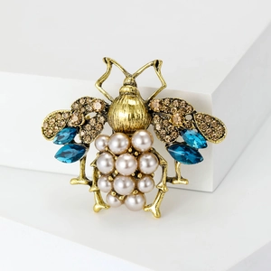 Detail of vintage gold bee brooch with brown diamonds, blue crystals and pearls