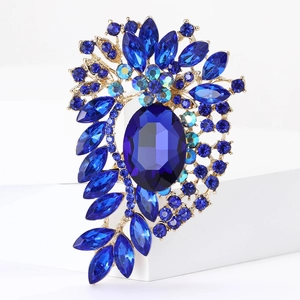 Detail view of vintage blue crystal floral brooch with golden alloy setting on white stand