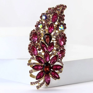 Detail of vintage gold flower brooch with deep pink crystals and rhinestones