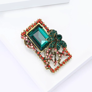 Baroque vintage brooch with large emerald-cut green crystal in antique gold frame