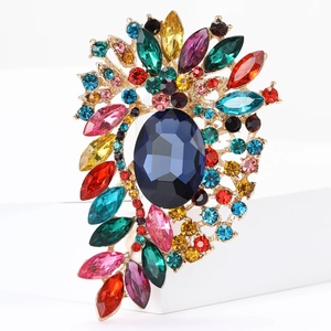 Macro shot of luxury colorful rhinestone brooch with a deep blue oval gem in gold alloy
