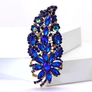 Detailed macro view of luxury floral brooch with navy blue crystals and gold setting