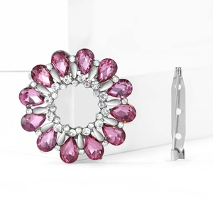 Vue détaillée d'une broche couronne argentée avec cristaux roses et petits diamants blancs