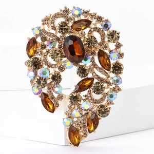 Detailed close-up of a gold-plated brooch with brown gems and sparkling AB rhinestones