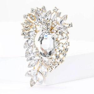 Detail of luxury gold brooch with radiant diamond-cut crystals and oval center stone