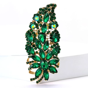 Exquisite gold-plated brooch with green and iridescent crystals on white display