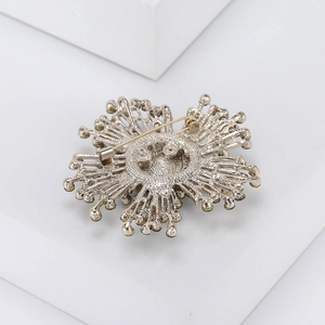 Macro view of geometric silver alloy brooch back showing intricate hollow design and pin