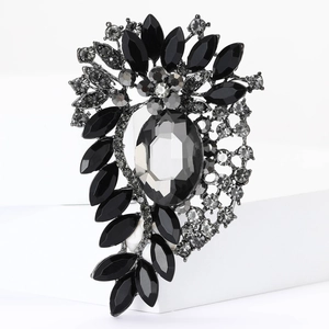 Detailed macro view of luxury grey crystal brooch with rhinestones on white pedestal