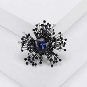 Vintage geometric brooch with dark blue crystal centerpiece and silver starburst frame