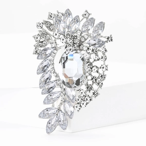 Macro detail of silver flower brooch featuring large oval crystal and marquise rhinestones