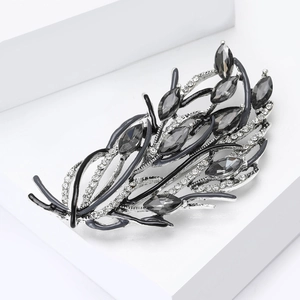 Gros plan sur une broche vintage en argent avec pierres marquises et strass brillants