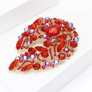 Elegant vintage gold alloy brooch with red rhinestones on a white geometric stage