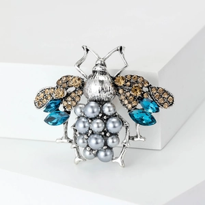 Vintage bee brooch with blue crystals and grey pearls on a retro silver base