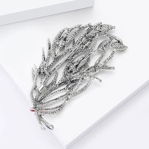 Broche plume en argent vintage avec accents en émail coloré sur support blanc