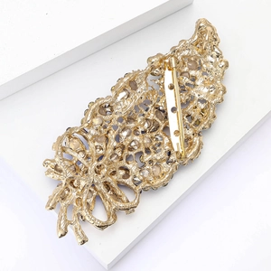 Detailed back view of vintage gold alloy brooch showing blue gems and secure pin closure