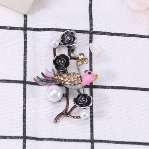 Detailed macro view of retro bird brooch with crystals, enamel petals, and pearls