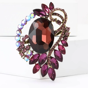 Macro detail of high-grade alloy brooch with large brown gemstone and colorful rhinestones