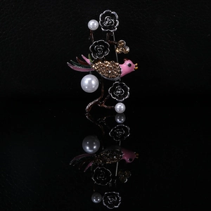Detail of bird brooch with pink lacquer head, crystal body and white pearls on black branch