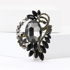 Close-up of vintage alloy brooch with grey oval crystal and black marquise rhinestones