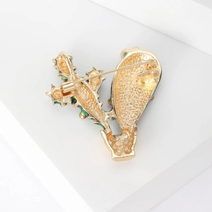 Back view of a gold cactus brooch with rhinestones showing the secure safety pin clasp