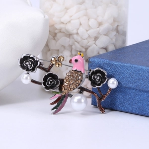 Detail of vintage bird brooch with amber rhinestones, black roses, and white pearls