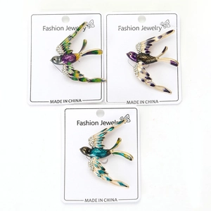 Trois broches hirondelles émaillées avec strass sur carte de bijoux tendance