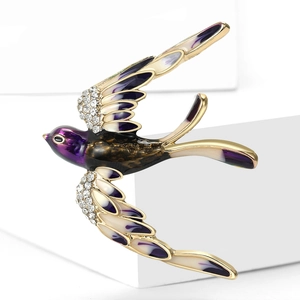 Détail de la broche hirondelle dorée avec émail violet et cristaux brillants étincelants