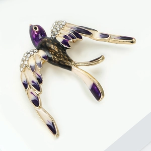 Détail macro de broche hirondelle avec émail violet et strass en cristal scintillants