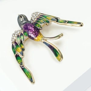 Détail de la broche hirondelle en émail coloré avec des strass brillants sertis