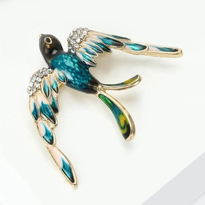Détail macro d'une broche oiseau hirondelle avec émail coloré et cristaux étincelants