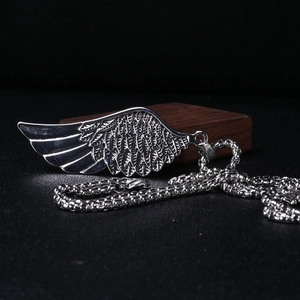 Détail de collier avec pendentif plume en argent vintage en acier titane robuste