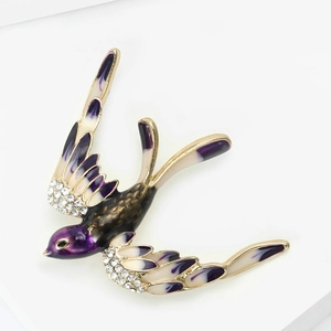 Détail de la broche hirondelle avec émail violet et cristaux blancs sur base dorée