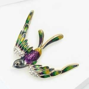 Gros plan détaillé d'une broche hirondelle avec ailes en émail coloré et strass brillants