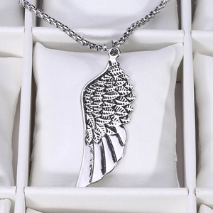 Vue macro détaillée d'un pendentif aile de plume argentée avec texture vintage sur boîte