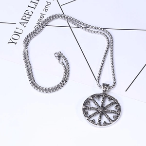 Détail du pendentif roue vintage en argent avec chaîne à mailles et fermoir mousqueton