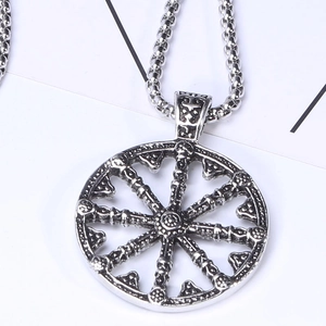 Gros plan du pendentif roue du dharma rétro en argent avec relief et chaîne à billes