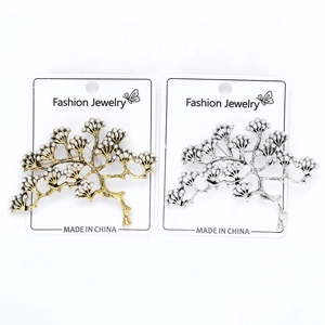 Gros plan de broches de branche de pin vintage avec perles élégantes en doré et argenté