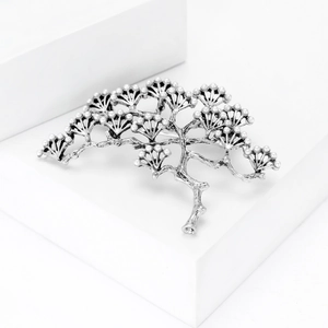 Détail de la broche branche de pin vintage avec perles blanches et texture ciselée