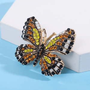 Eleganter Schmetterlings-Brosche aus Gold mit bunten Strasssteinen auf blauem Hintergrund