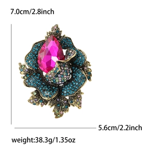 Retro vintage floral brooch with blue rhinestones and pink crystal in a golden finish