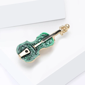 Broche élégante en forme de violon en émail vert et or sur présentoir blanc moderne